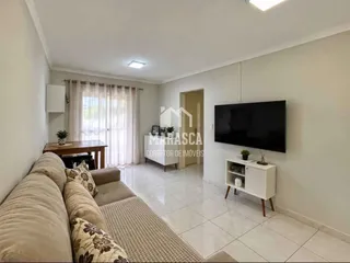 Sala de estar clara com janela e televisão.