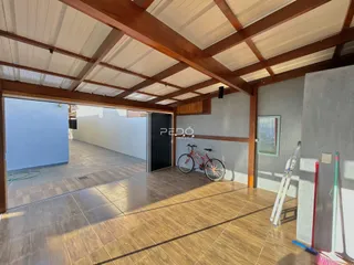 Interior de um ambiente com teto de madeira exposto e piso de cerâmica.