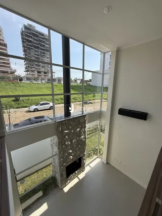Vista de uma sala de estar com grandes janelas que dão para um jardim.