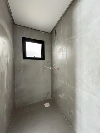 Hall de entrada com paredes cinzas e uma janela.