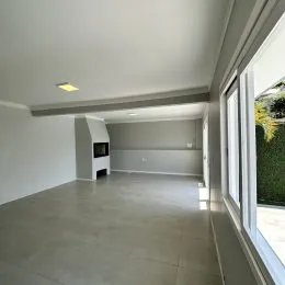 Vista de um corredor interno com paredes brancas e piso claro.