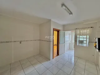 Interior de uma sala com piso de cerâmica e paredes brancas.