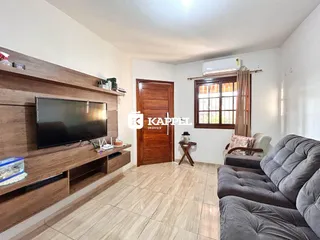 Uma sala de estar com sofá e televisão montada na parede.