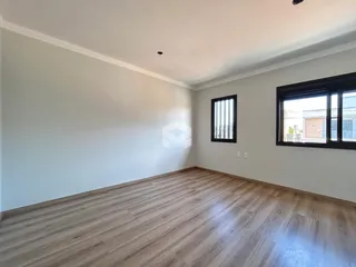 Sala de estar com piso de madeira clara e paredes brancas.