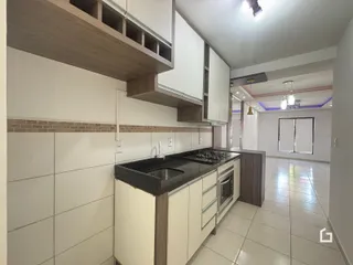 Foto da cozinha com armários brancos e revestimento de tijolos.