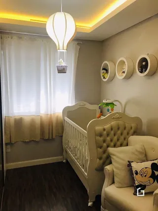 Quarto com cama e cortinas brancas em um imóvel.