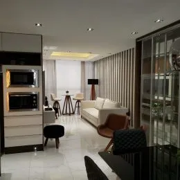 Sala de estar com paredes brancas e móveis claros.