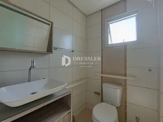 Foto de um banheiro com azulejos brancos e uma janela.