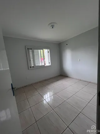 Foto interna de um cômodo com piso de cerâmica e janela.