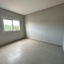 Foto de um cômodo interno com paredes claras e uma janela.