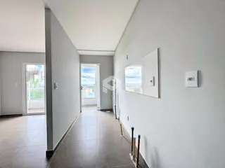 Corredor interno de uma residência com piso de cerâmica.