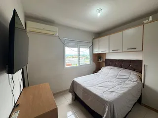 Quarto com cama e armários em um apartamento em Lajeado, Brasil.