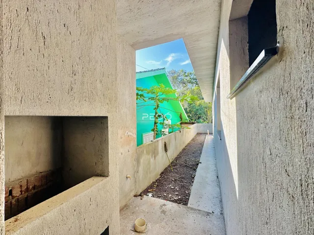 Vista de um corredor externo entre duas estruturas de concreto.