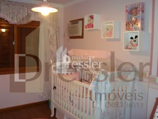Quarto com cama de madeira e cortinas brancas em uma residência.