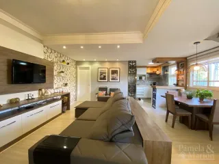 Sala de estar com sofá e televisão em ambiente interno.