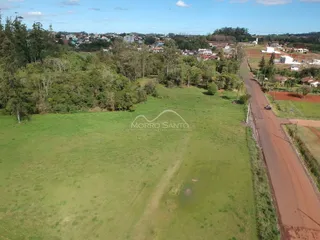 Vista aérea de um terreno gramado com vegetação ao redor.