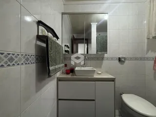 Interior de um banheiro com azulejos brancos e bancada branca.