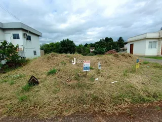 Vista externa de uma propriedade com vegetação seca no primeiro plano.