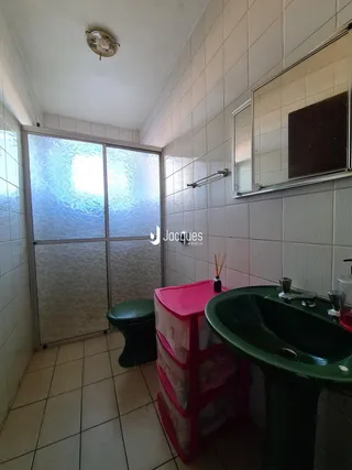 Foto interna de um banheiro com revestimento cerâmico nas paredes e piso.