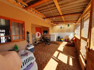 A foto mostra o interior de uma sala com teto de madeira aparente.