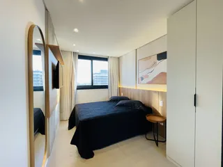 Quarto moderno com cama e janela em um apartamento.