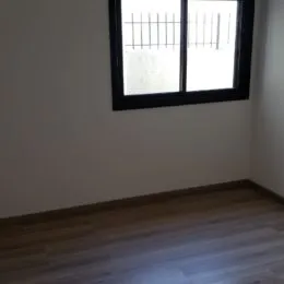 Vista de uma parede interna com uma janela em um imóvel.