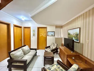 Sala de estar com móveis de madeira e portas de madeira em um imóvel no Brasil.