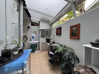 Vista de um corredor interno com paredes brancas e piso de cerâmica.