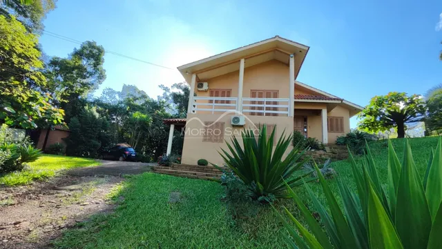 Foto da fachada de uma casa em Lajeado, Brasil, com jardim verde e varanda.
