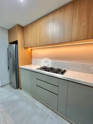 Cozinha moderna com armários de madeira e bancada clara.