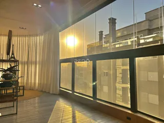 Vista da sala de estar com grandes janelas de vidro em um imóvel em Lajeado.