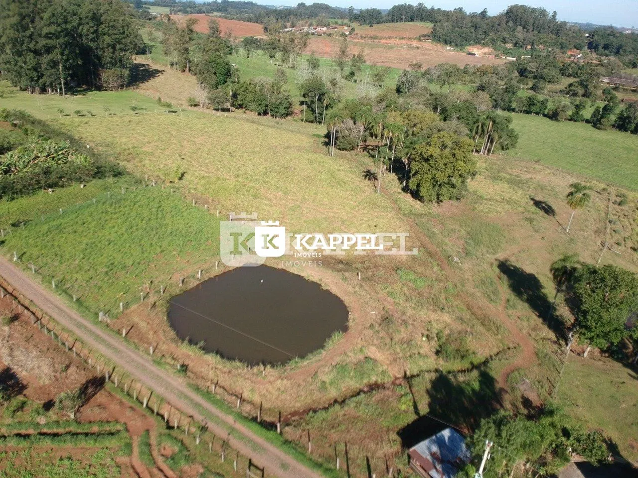 Vista aérea de uma área rural com campos e um lago em Lajeado, Brasil.
