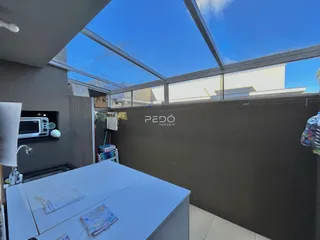Vista interna de um imóvel com teto de vidro e parede de fundo.