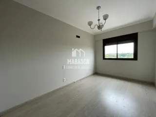 Ambiente interno com piso de madeira clara e janela grande.