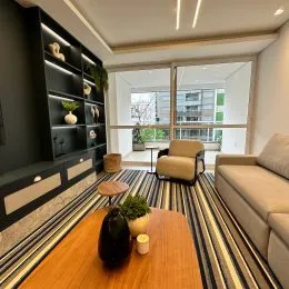 Sala de estar com painel de nichos e piso de madeira.