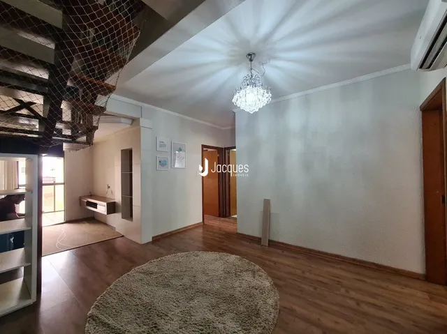 Sala de estar com piso de madeira e paredes brancas.