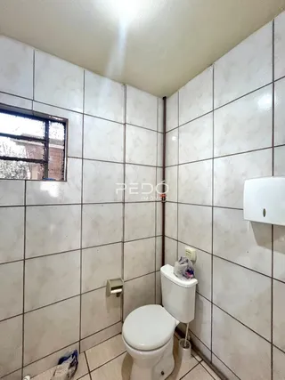 Foto de um banheiro com azulejos brancos.