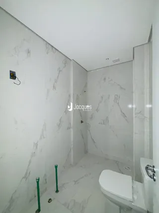 Foto de um banheiro com revestimento em mármore branco.
