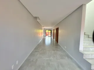 Vista de um corredor interno de uma residência com piso de cerâmica.