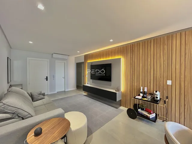 Sala de estar moderna com parede de madeira e piso claro.