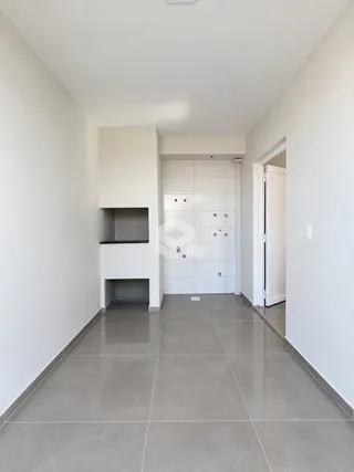 Corredor interno de uma residência com paredes brancas e piso de cerâmica.