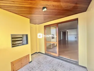 Hall de entrada com piso de cerâmica e teto de madeira aparente.