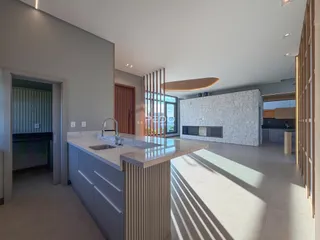Ambiente moderno de cozinha e sala de estar com ilha central.