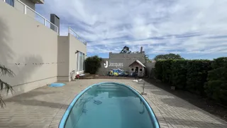 Vista externa de uma residência com piscina e parede branca em Lajeado.