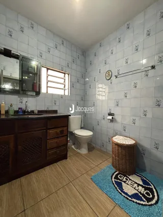 Foto de um banheiro com revestimento de azulejos e bancada de madeira escura.