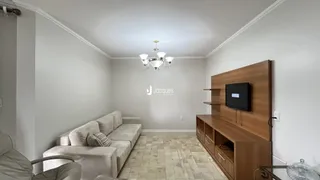 Sala de estar com sofá e painel de madeira na residência.