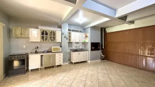 Cozinha com armários brancos e piso de cerâmica.