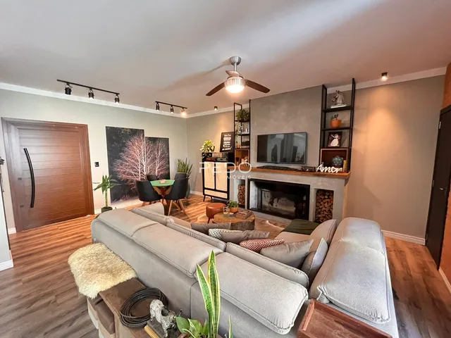Sala de estar com sofá grande e lareira em um imóvel no Brasil.