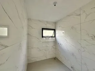 Parede com revestimento de mármore branco em um ambiente interno.