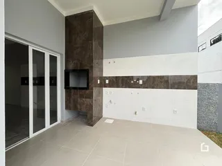 Interior de um espaço com paredes em tons de marrom e branco e piso claro.